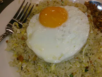 Riz sauté à l'œuf coulant et oignons frits